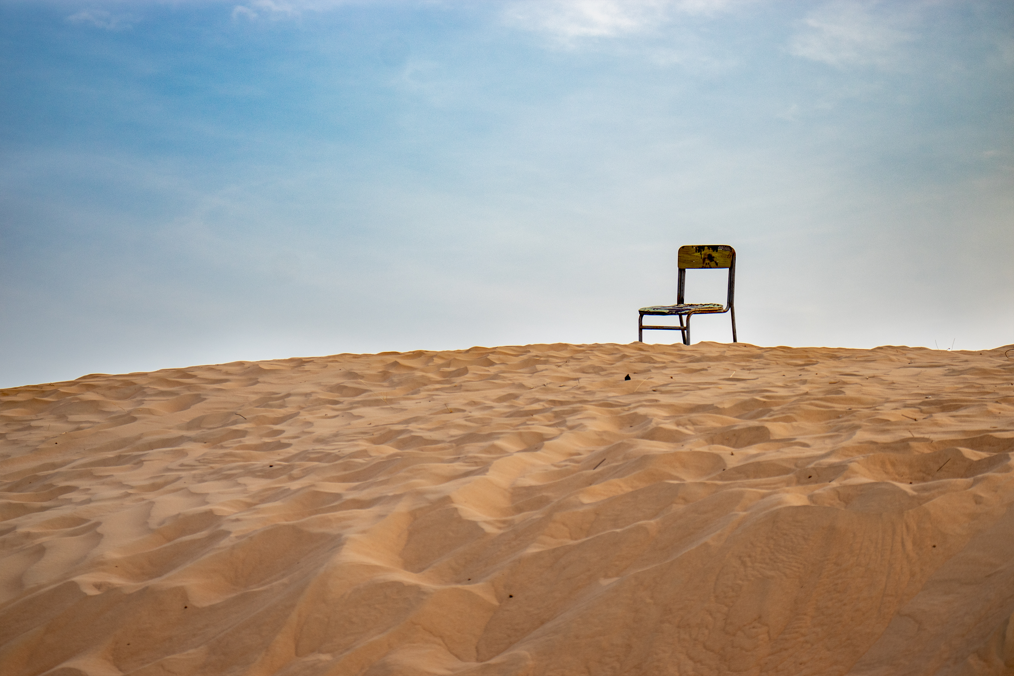 A photo of a chair on a hill of sand