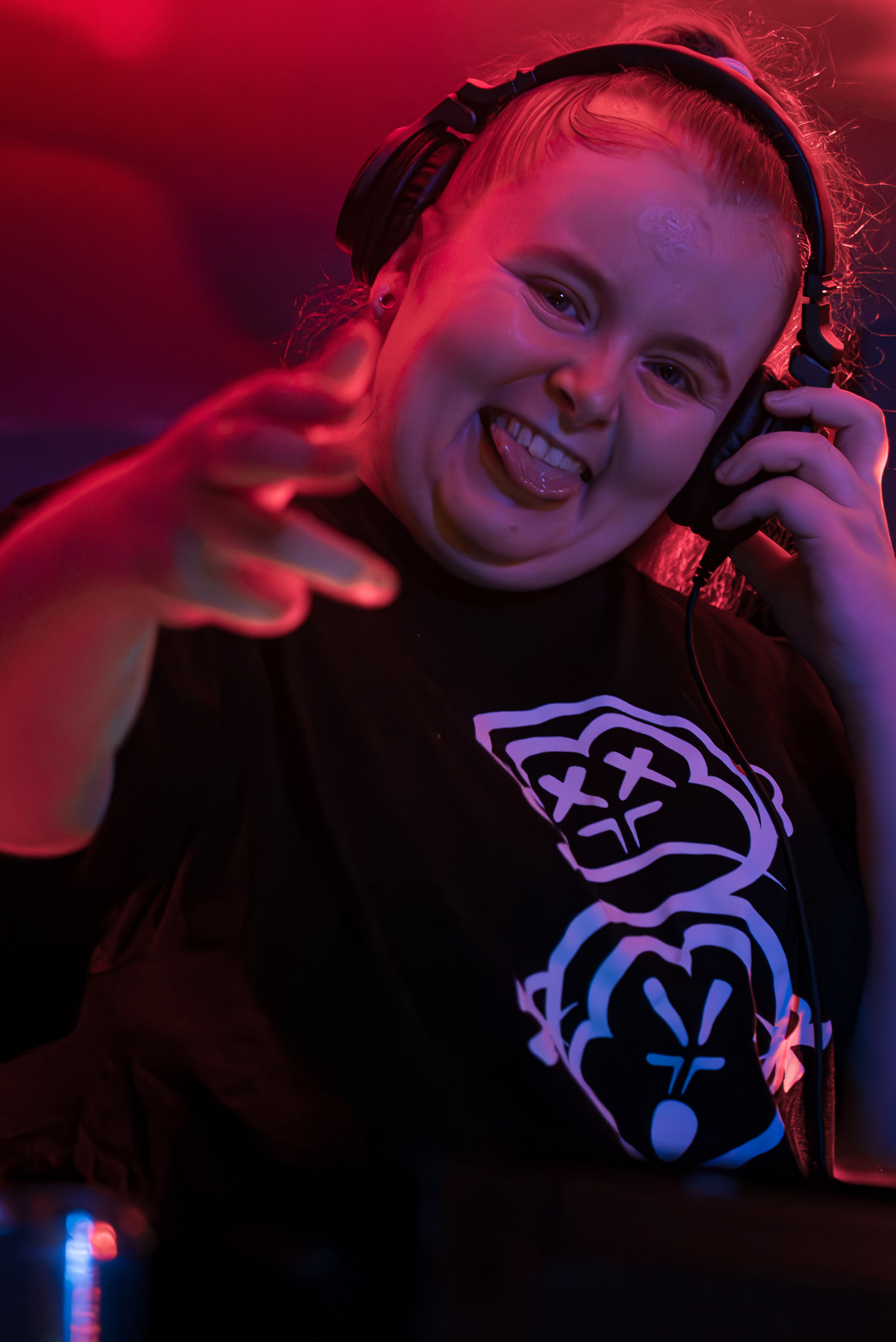 BLONDY wearing headphones looking at the camera and smiling with her tongue out