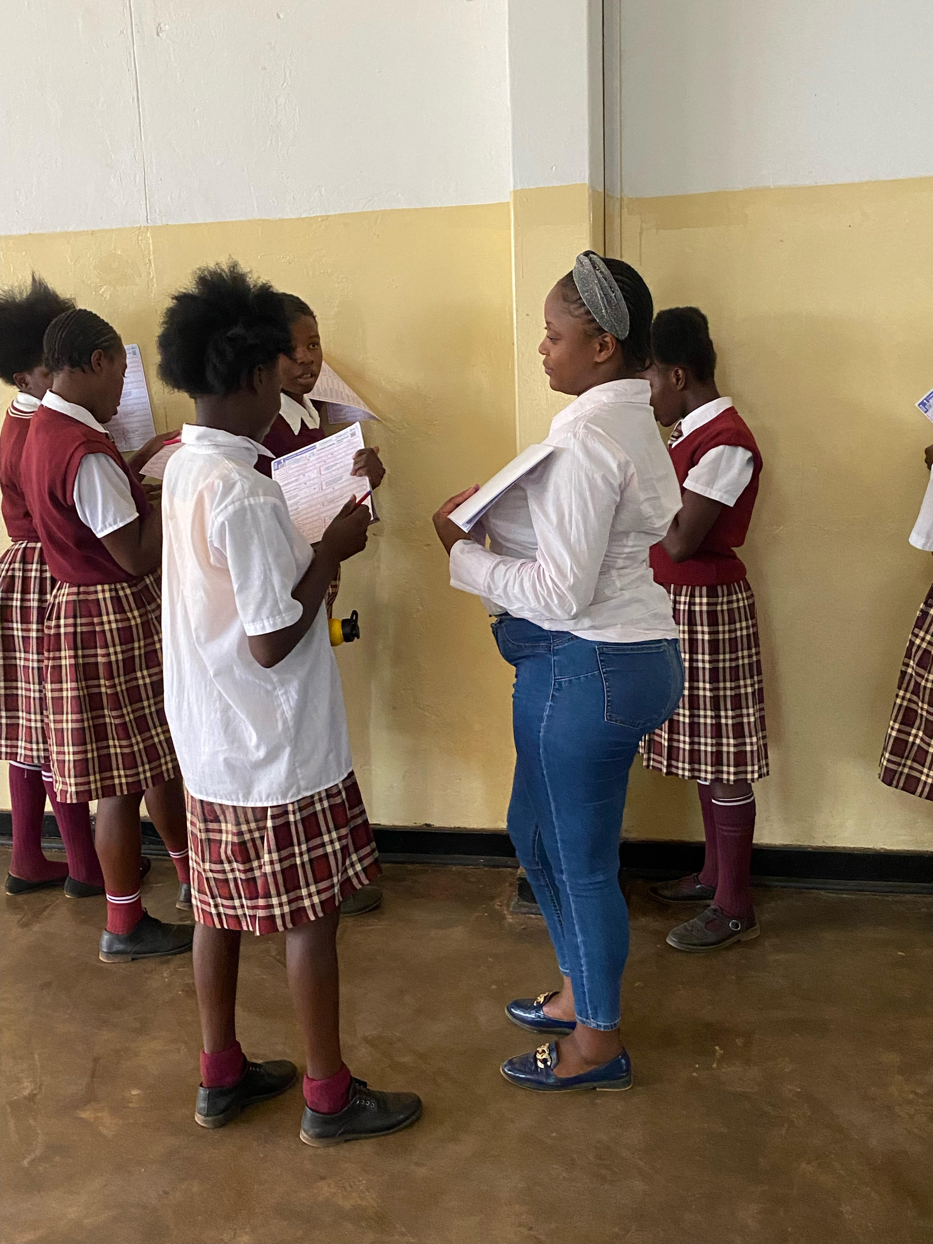 Charity standing with a group of young people holding a book