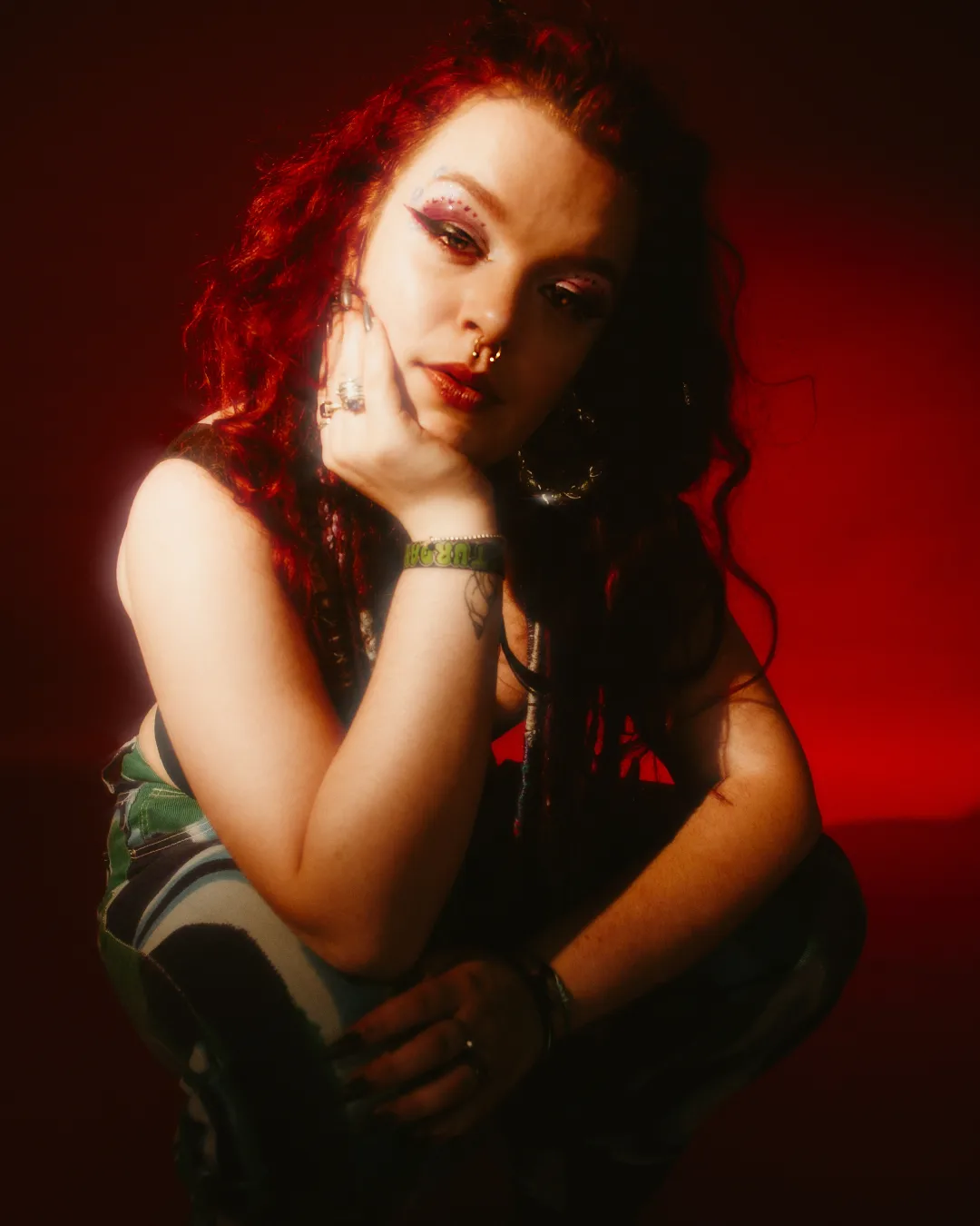  Rhi’N’B on a red background looking at the camera 