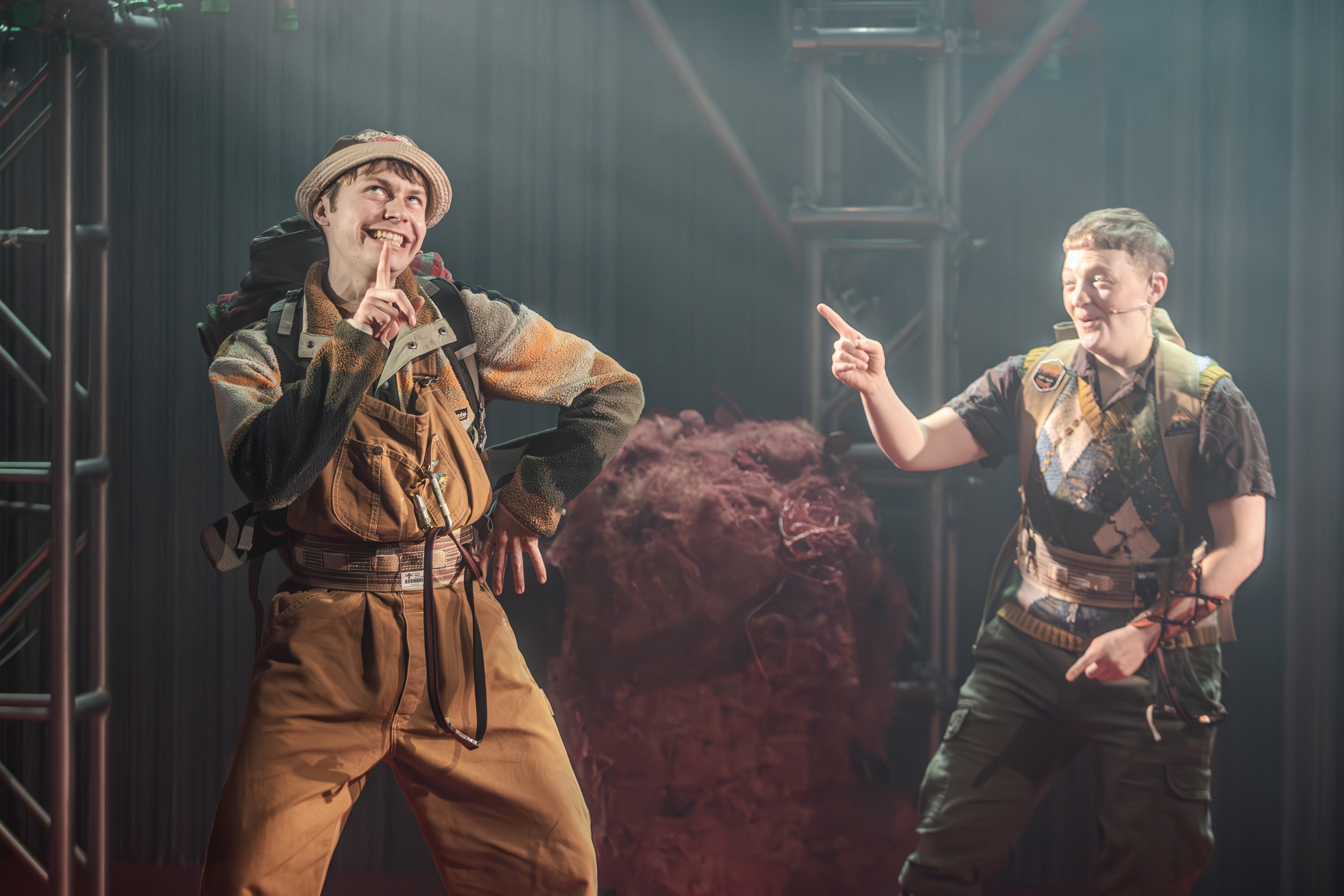 Tom performing on stage, in costume with a finger on his chin