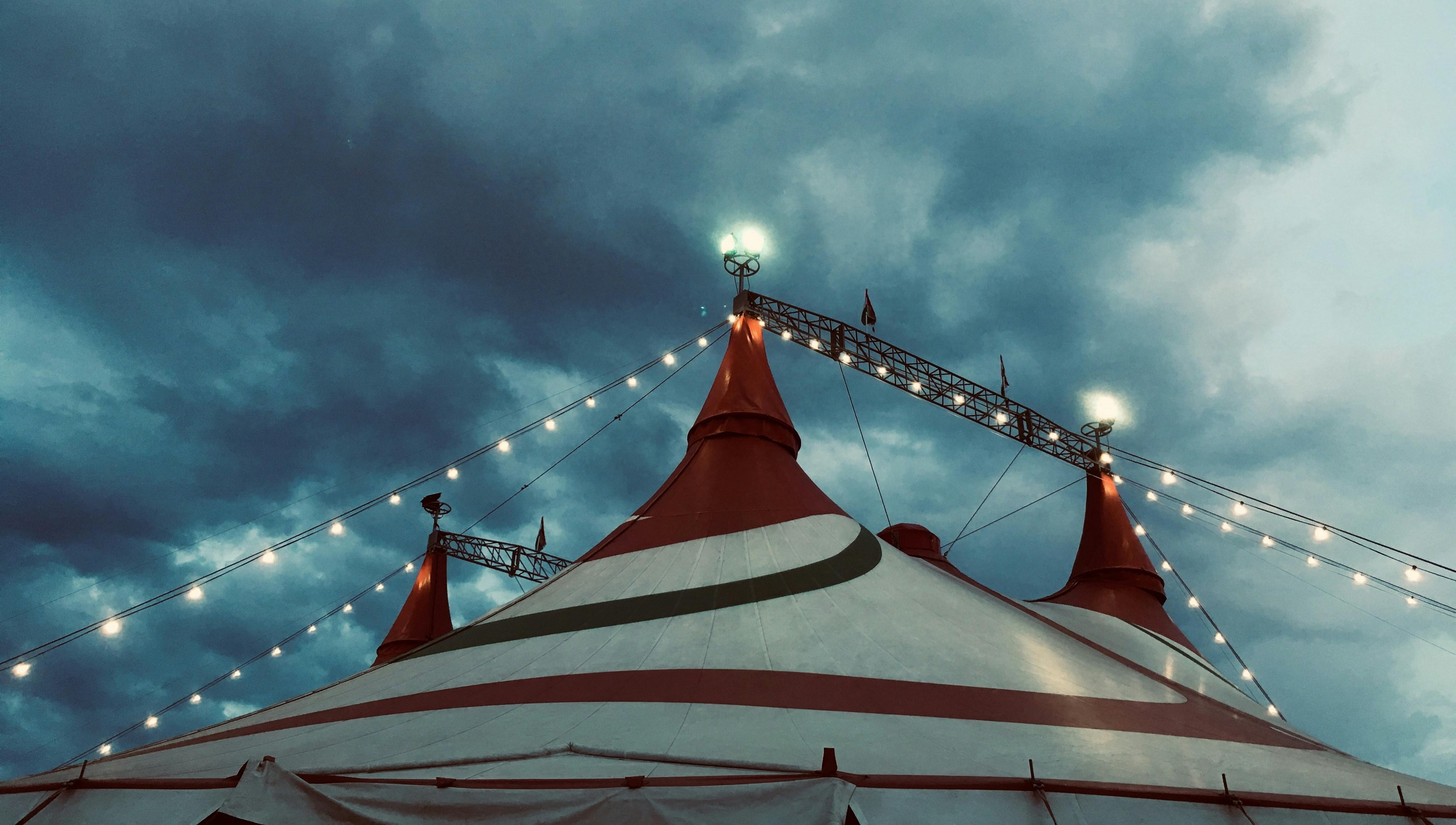 top of a circus tent in front of a cloudy sky