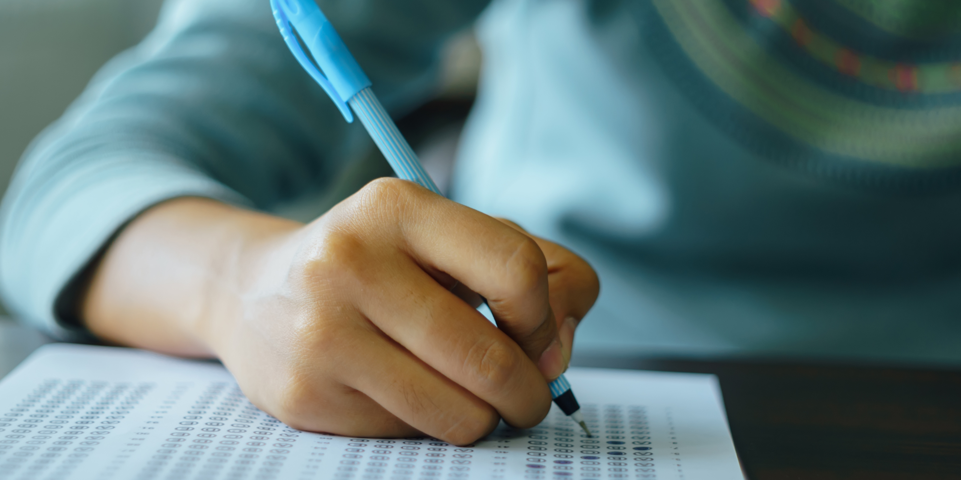 person filling in a multiple choice exam sheet 