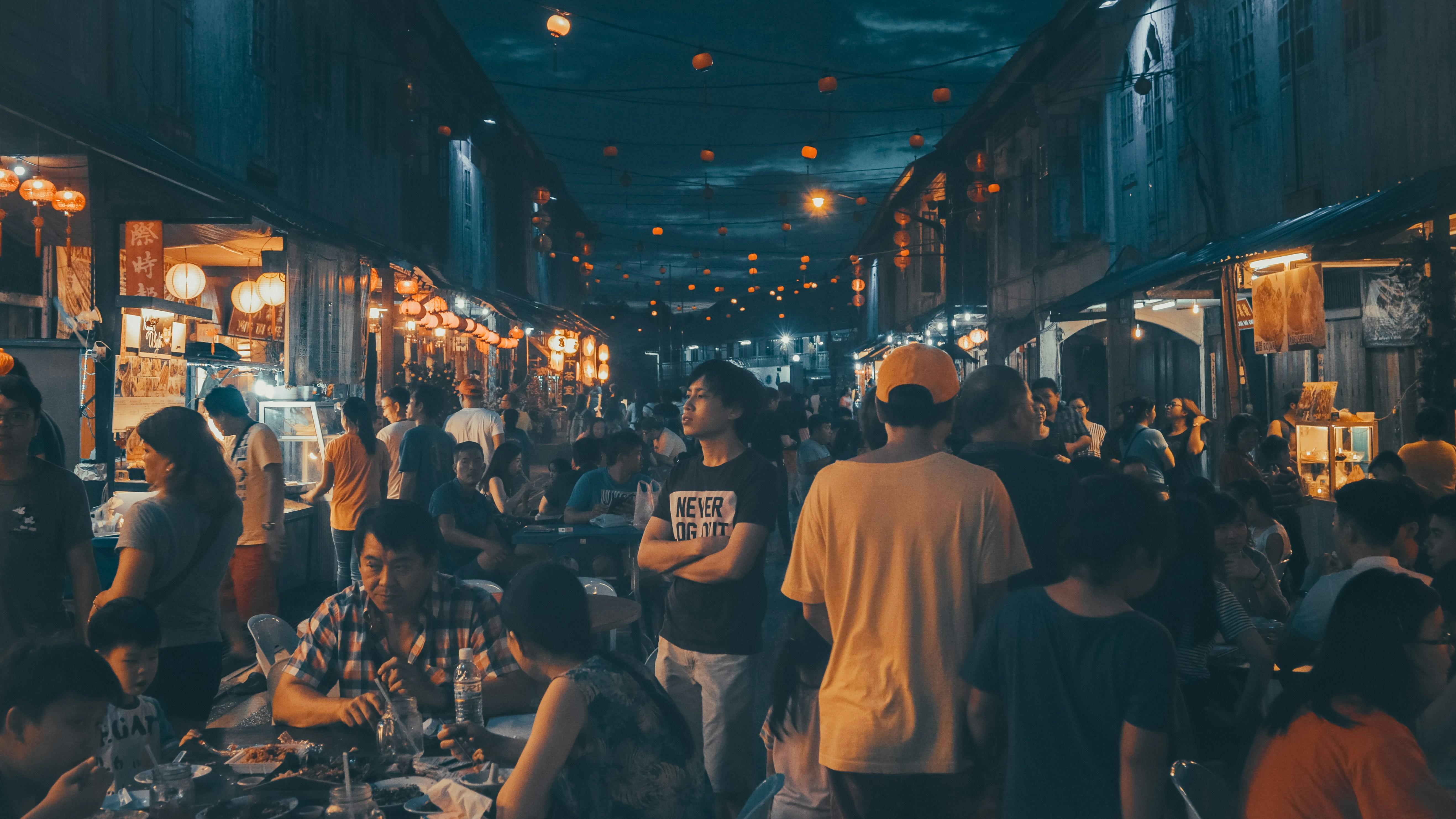 Young person standing in a crowded Sarawak Night Market in Malaysia 