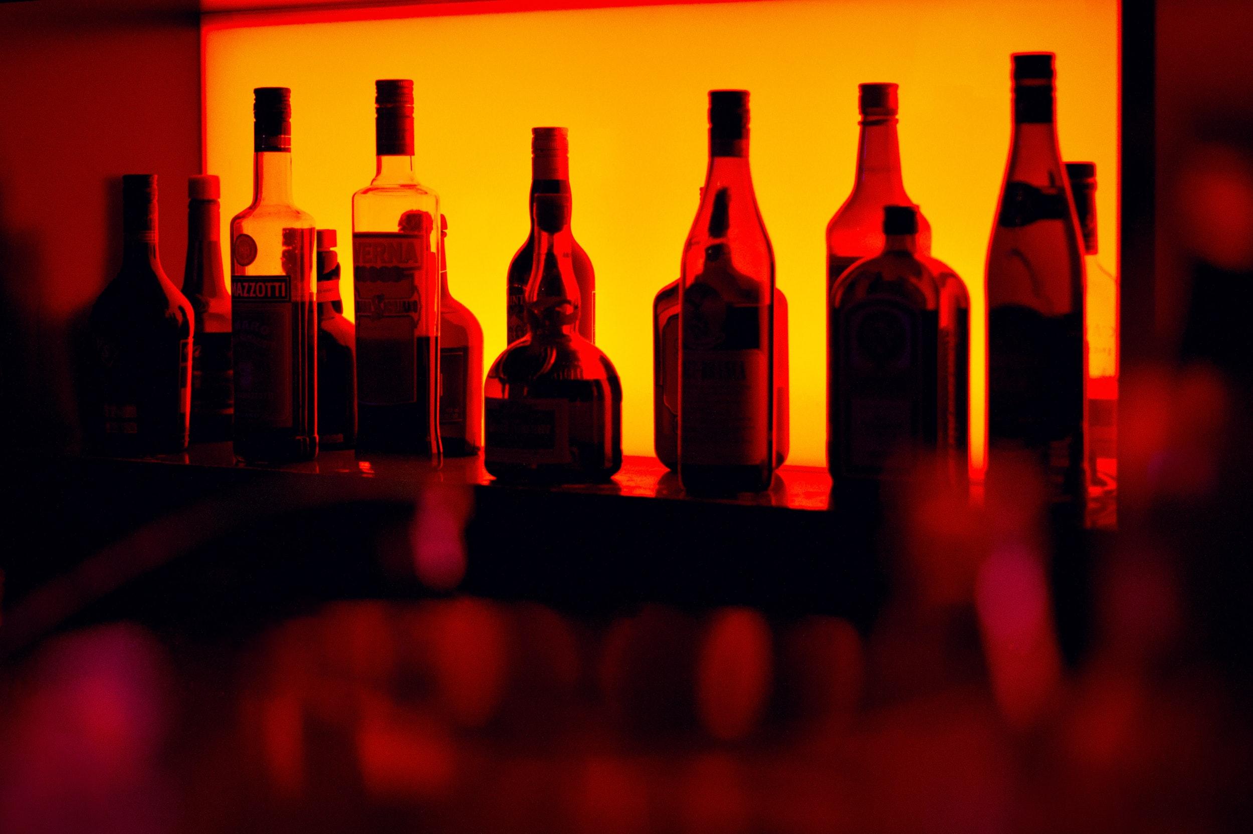 a photo of liquor bottles in red lighting