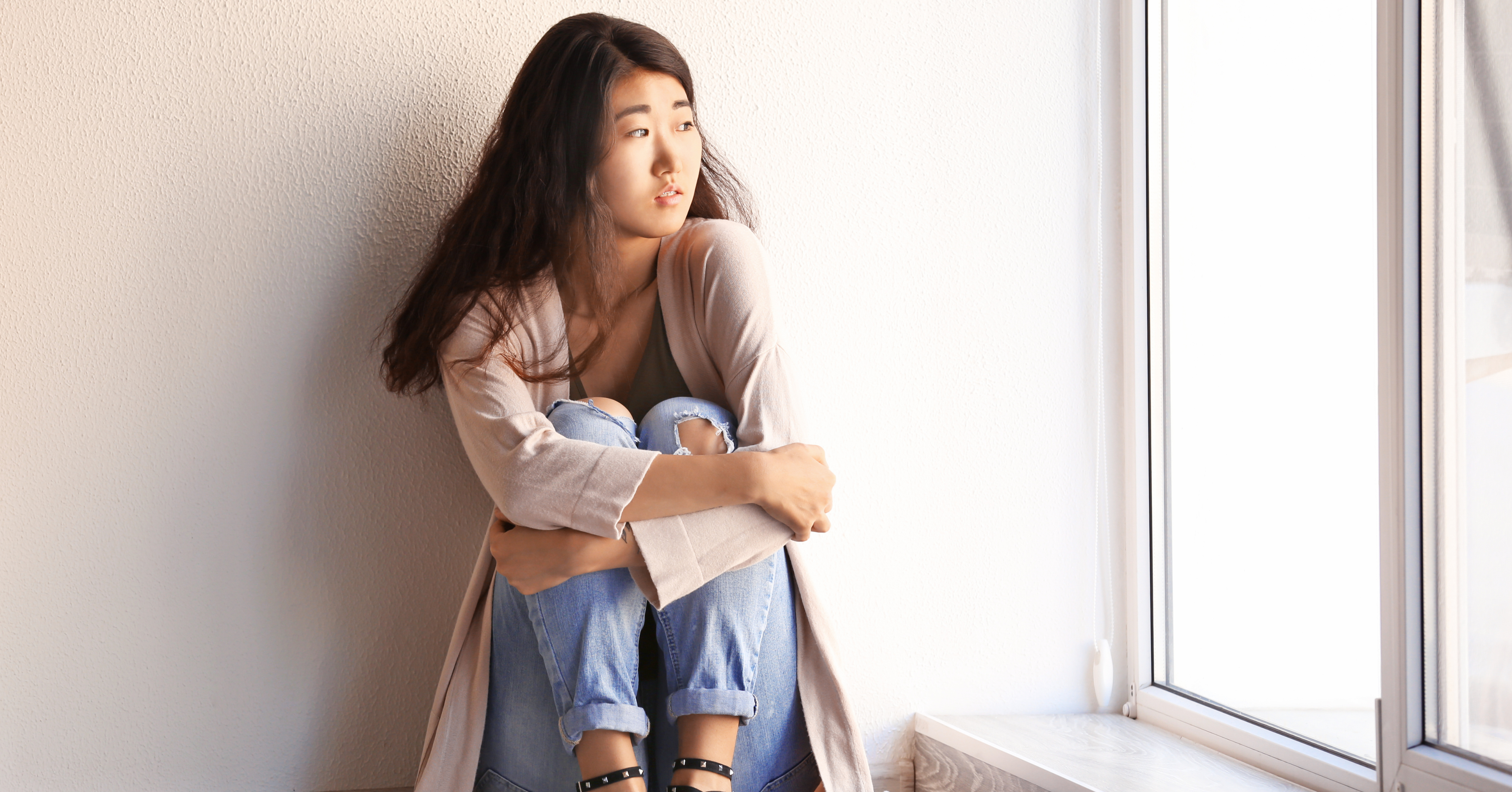 Girl sitting on the floor looking out the window