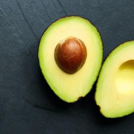 a halved avocado on a gray background