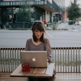 woman sitting at a table working on her laptop