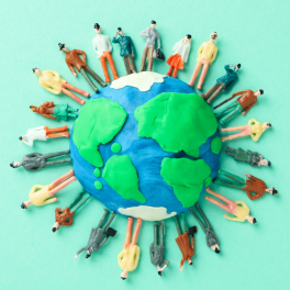 clay people standing around a clay model of the earth