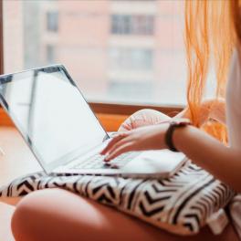 young woman typing on a laptop