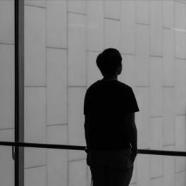 silhouette of a person standing in front of a window alone