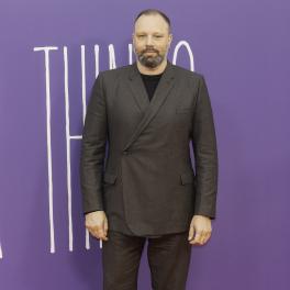 yorgos lanthimos standing in front of a purple backdrop