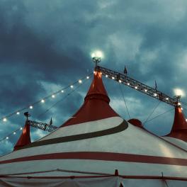 top of a circus tent in front of a cloudy sky