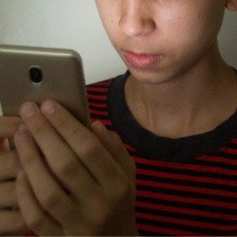 a teen boy looking at his phone