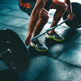 a man lifting a weighted barbell in a gym