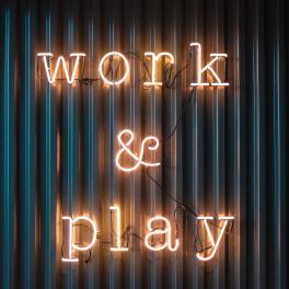 a neon sign that reads "work and play"
