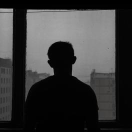 silhouette of man standing near a window