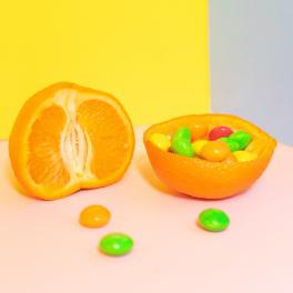 skittles in a hollowed out orange