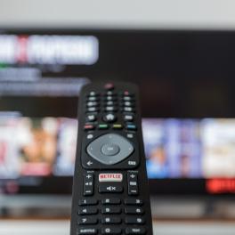 image of remote with tv screen in the background