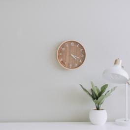 White desk with a white light, plant and clock