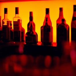 a photo of liquor bottles in red lighting