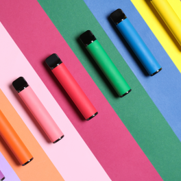vapes in assorted colors lined up on a colorful background