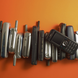 a pile of flip phones on an orange background