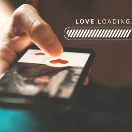 A person holding a phone with an online dating profile appearing on the screen