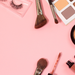 Makeup products spread out on a pink background