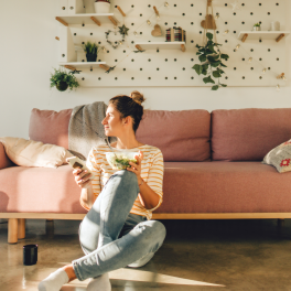 Woman sitting alone in her living room eating a salad