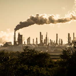 large smoke stack with smoke cloud drifting away from it