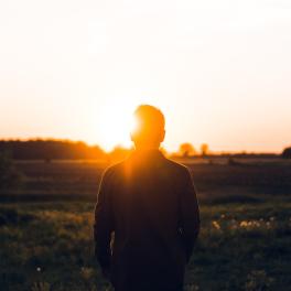 man facing the sunrise