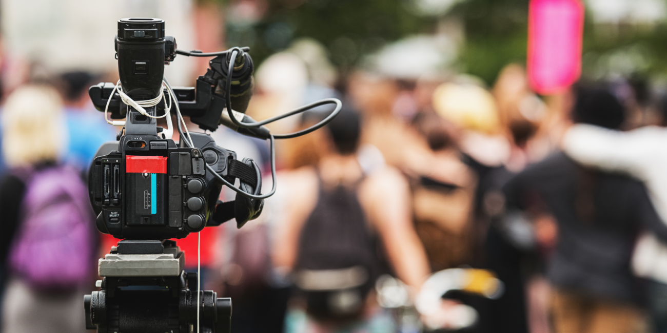 news camera pointed at a group of people