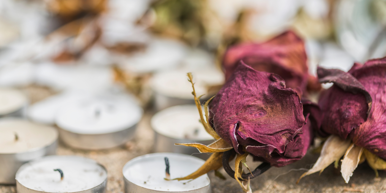 burnt candles and dead roses on the ground