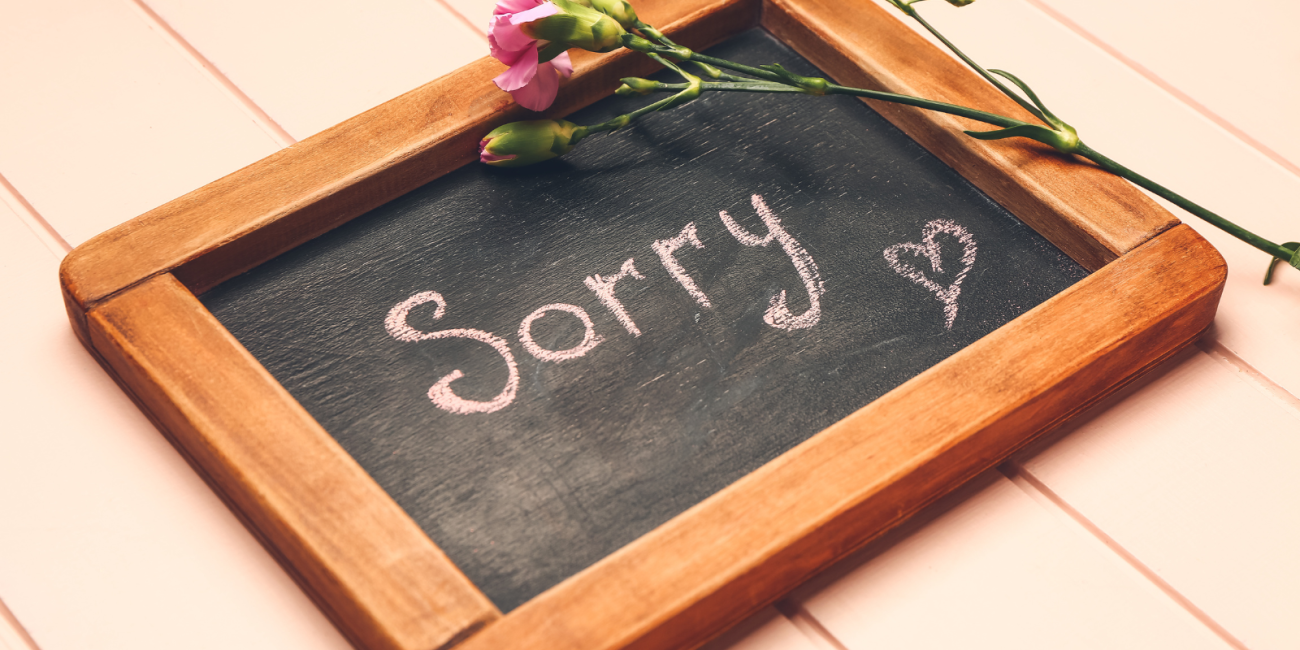 "sorry" written on a chalkboard