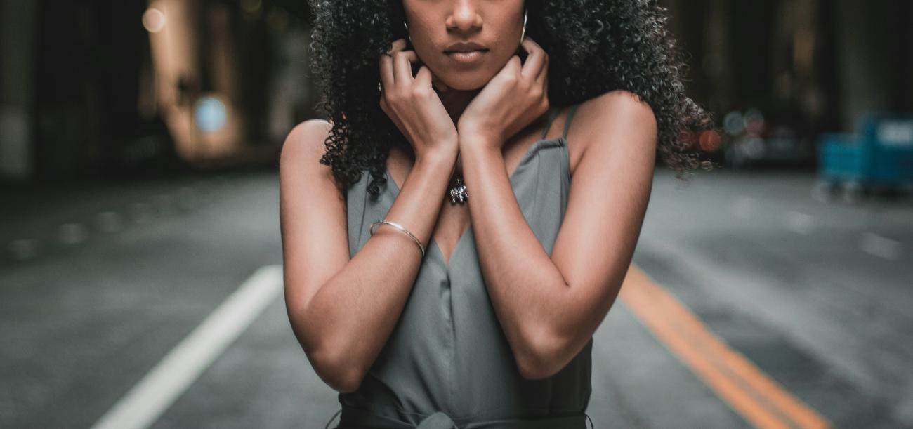 young black woman standing on a street facing the camera