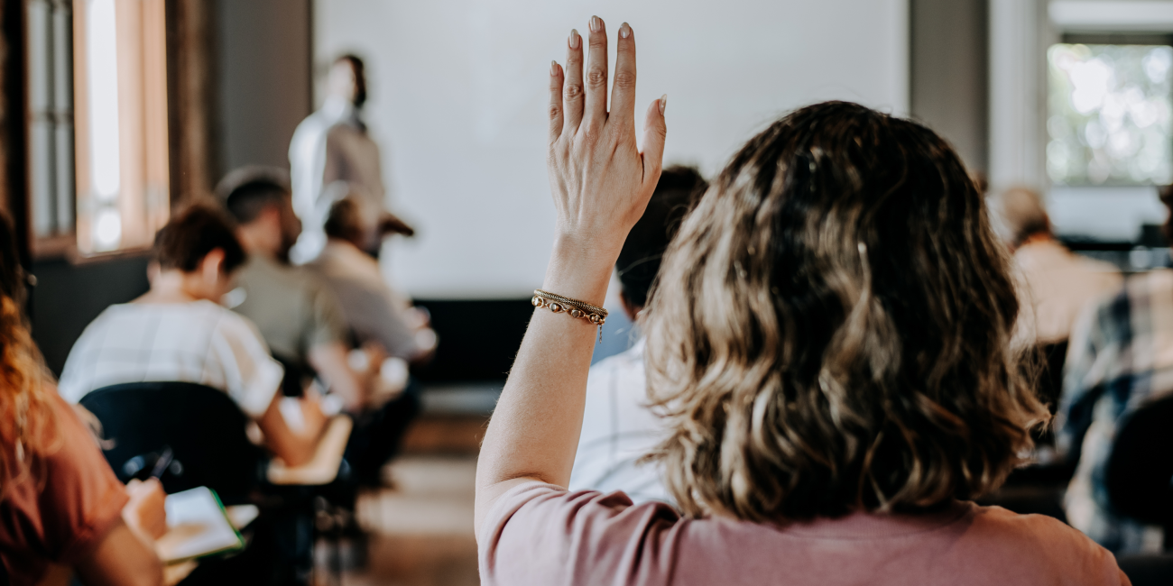 Female student raising her hand in the classroom 