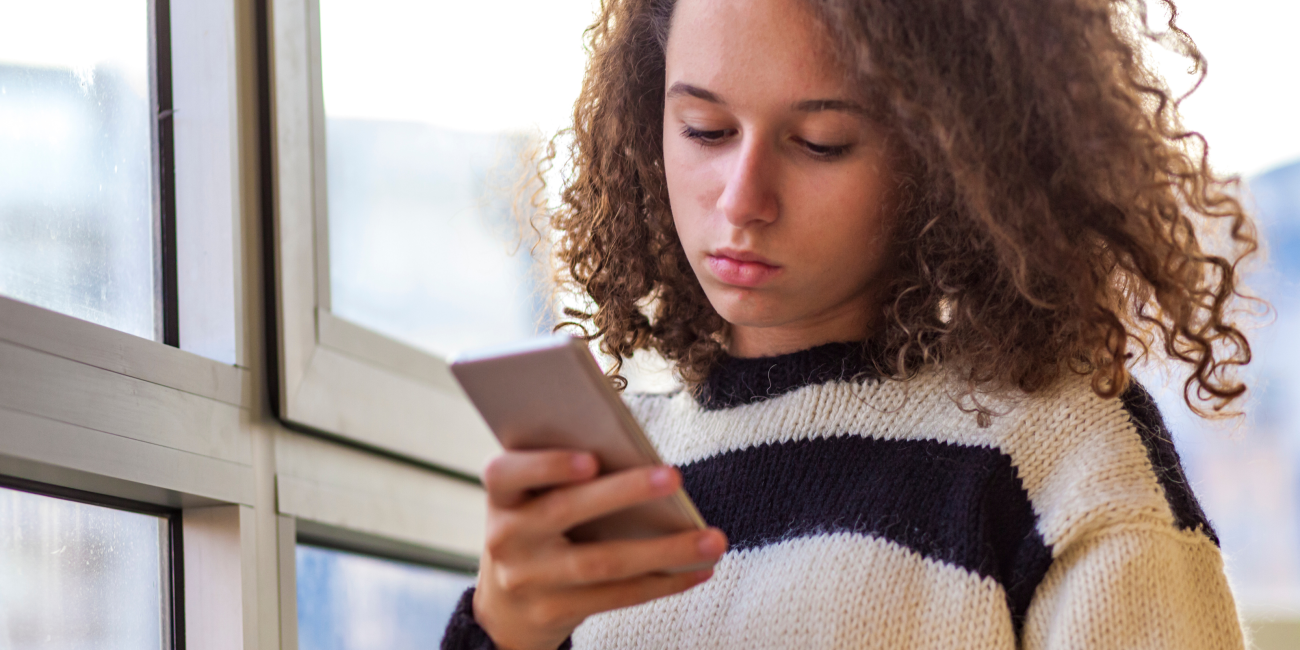 a teen girl looking at her cellphone