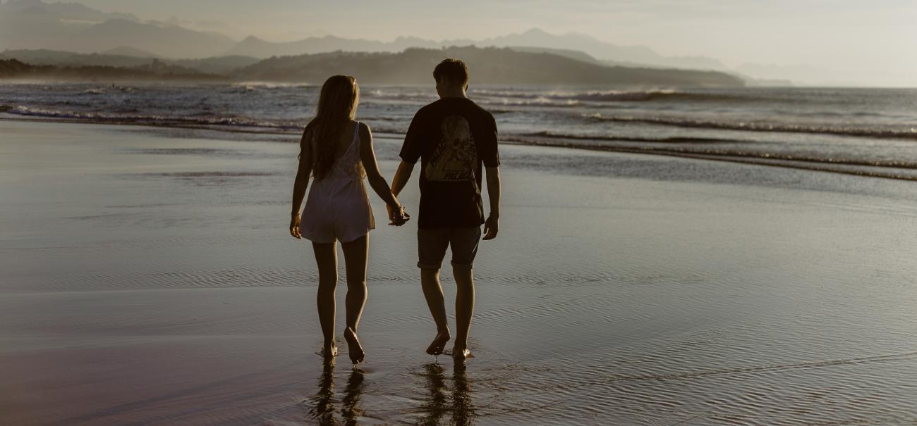 couple walking on the beach hand in hand 