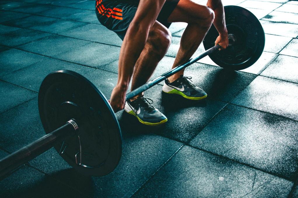 a man lifting a weighted barbell in a gym