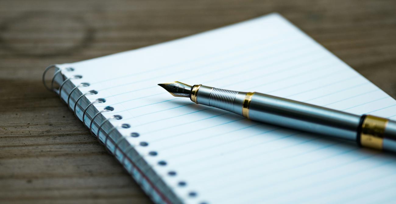 a fountain pen on a pad of paper