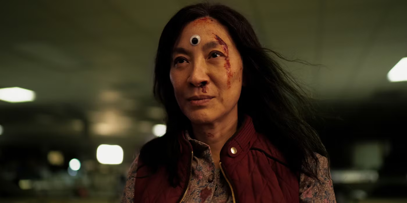 screenshot from the film Everything Everywhere all at once of the main character with a determined look on her face with a googly eye on her forehead 
