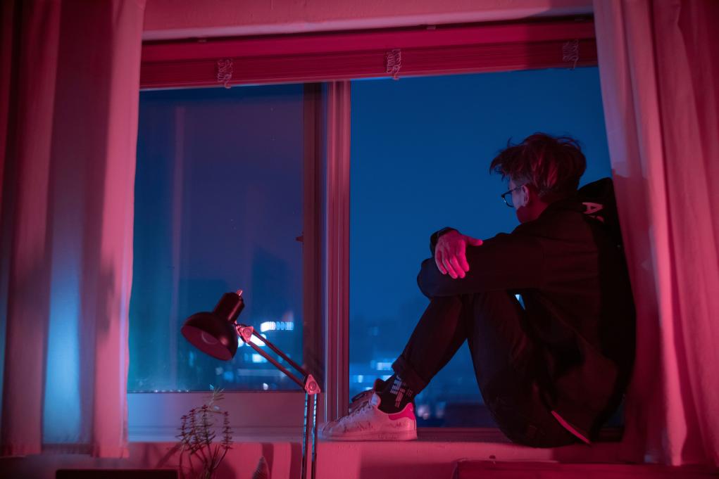 person sitting in a window looking out