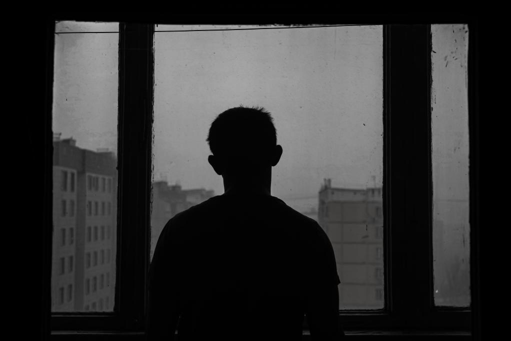 silhouette of man standing near a window
