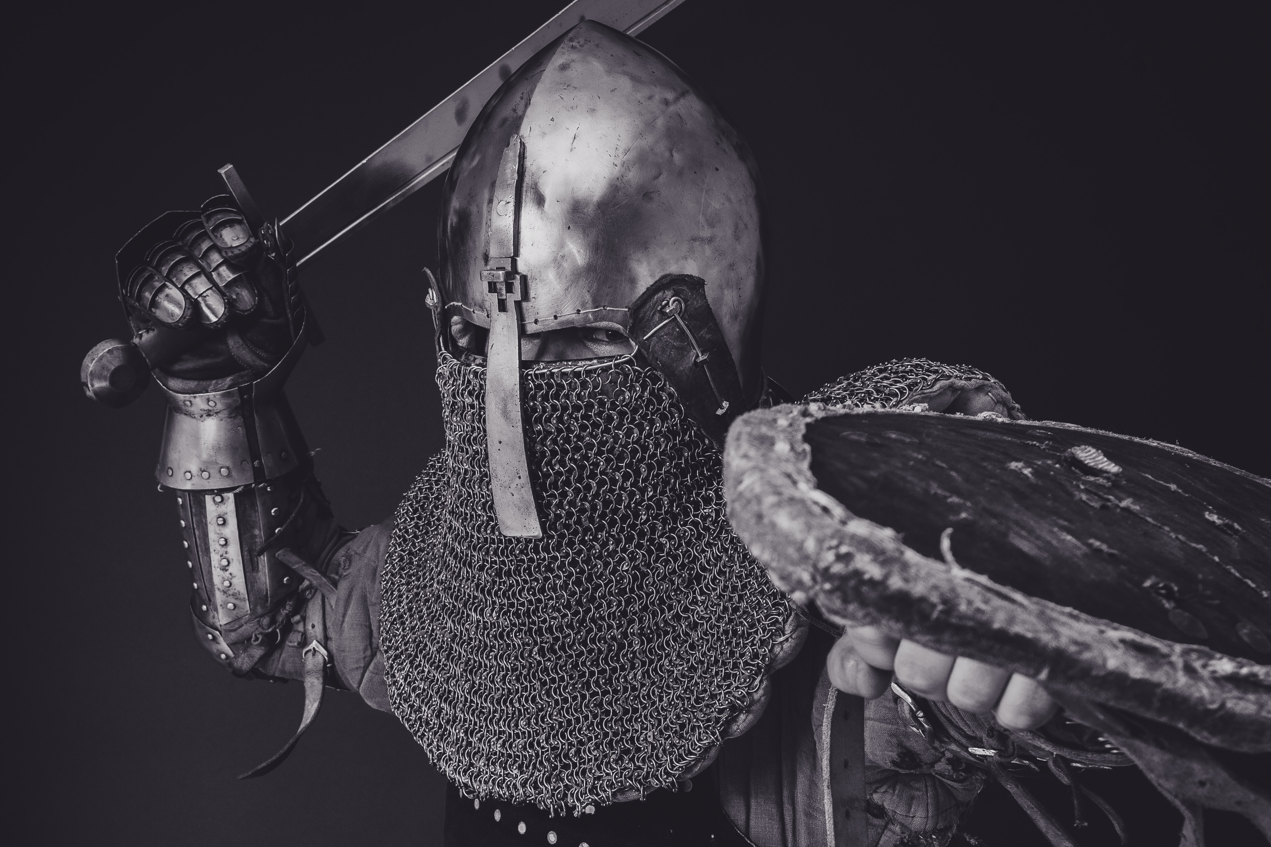 Black and white image of a knight in armor raising his sword