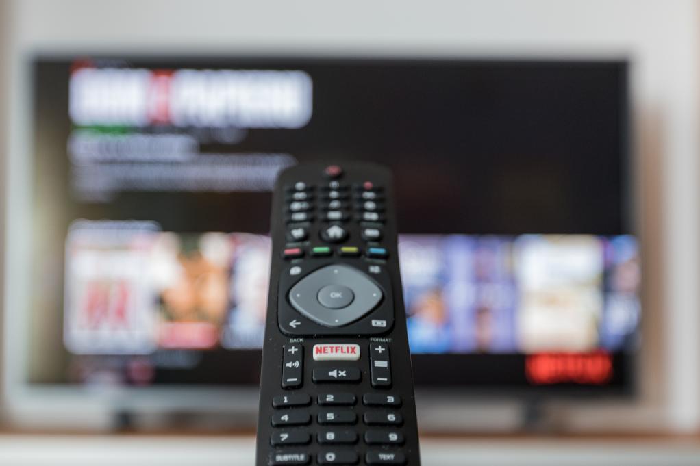 image of remote with tv screen in the background