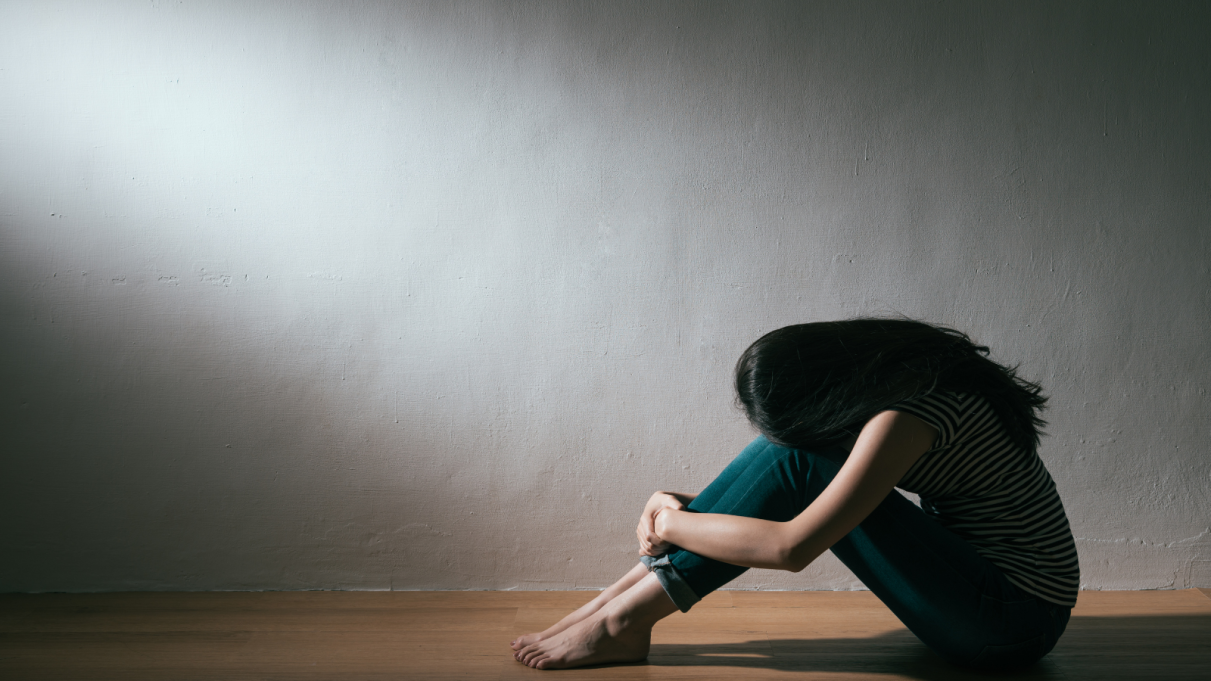 woman with her head in her lap