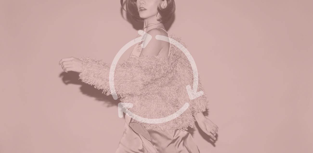 A woman walking with a fuzzy jacket on with a cycle symbol overlaid