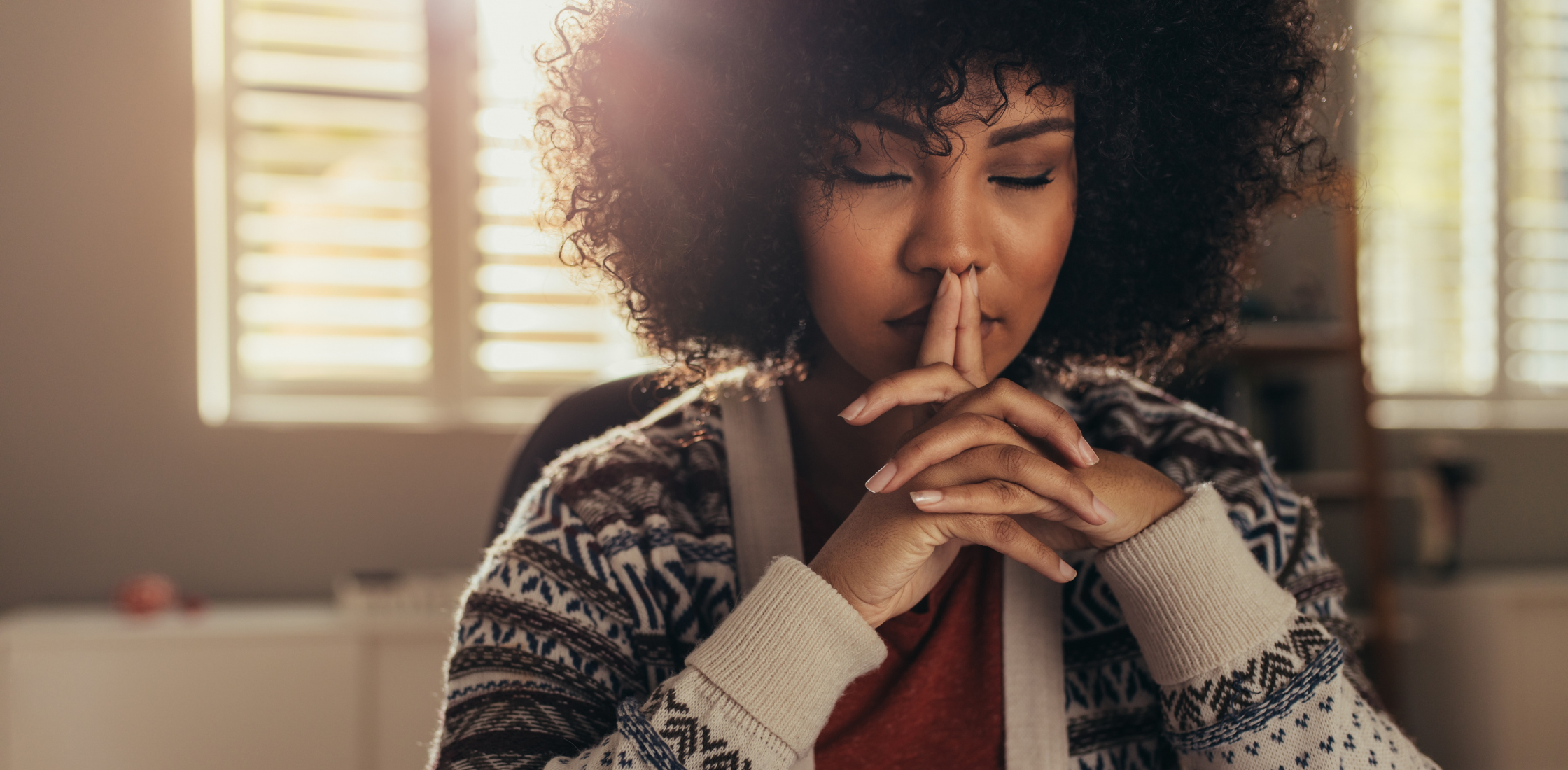 woman sitting with her eyes closed thinking
