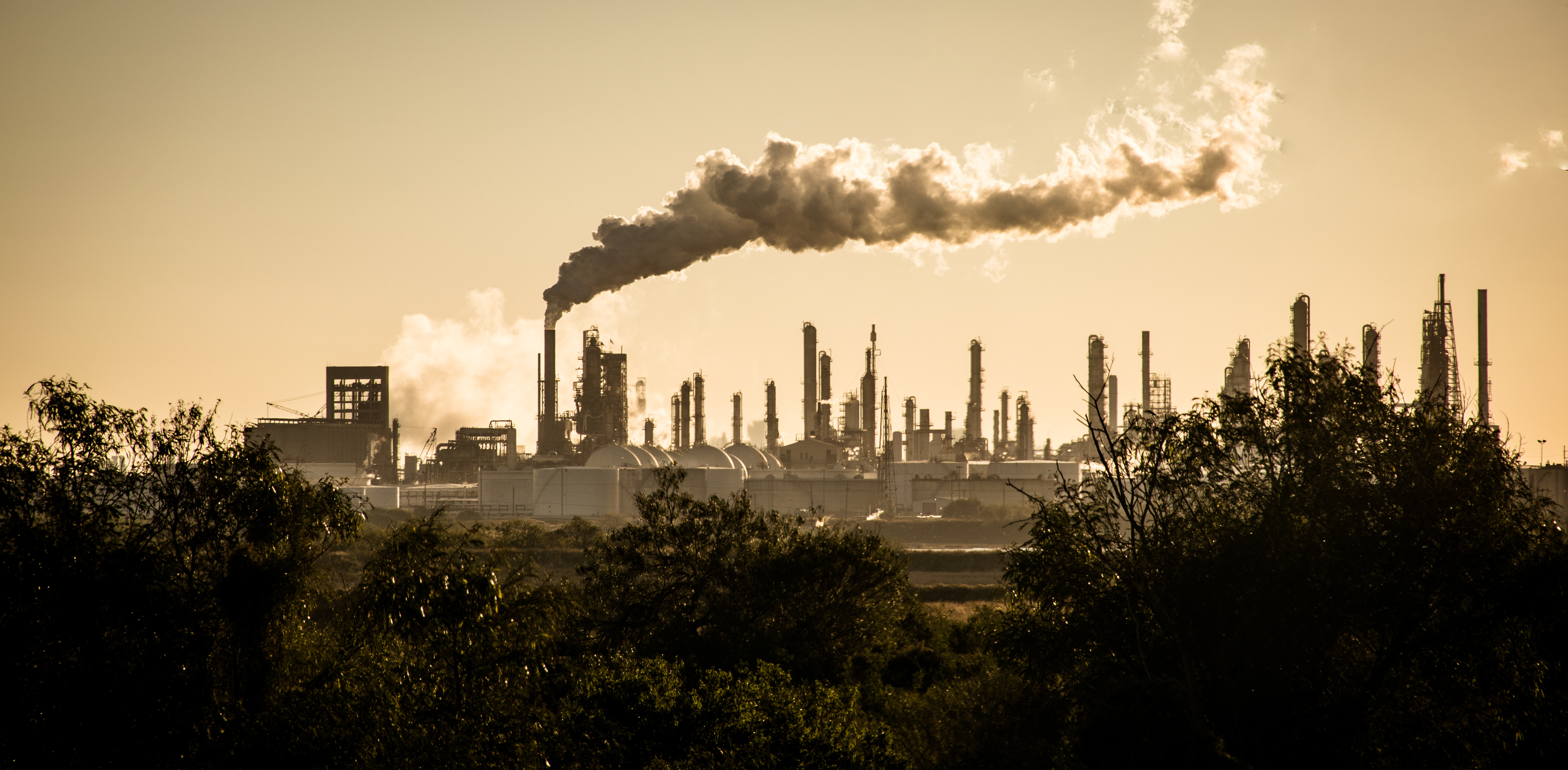 large smoke stack with smoke cloud drifting away from it